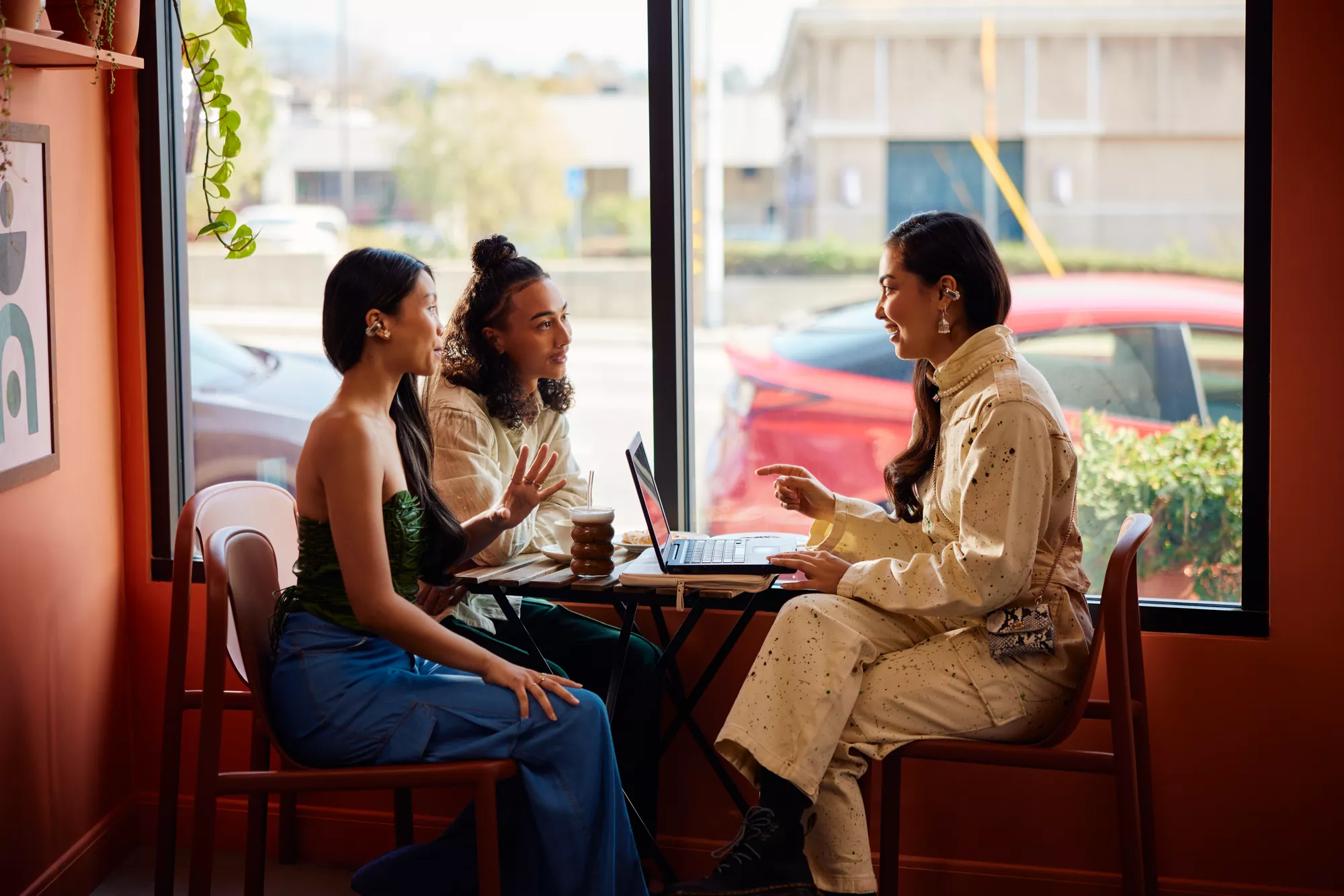 People in a meeting at a caf&eacute; wearing Bose Ultra Open Earbuds